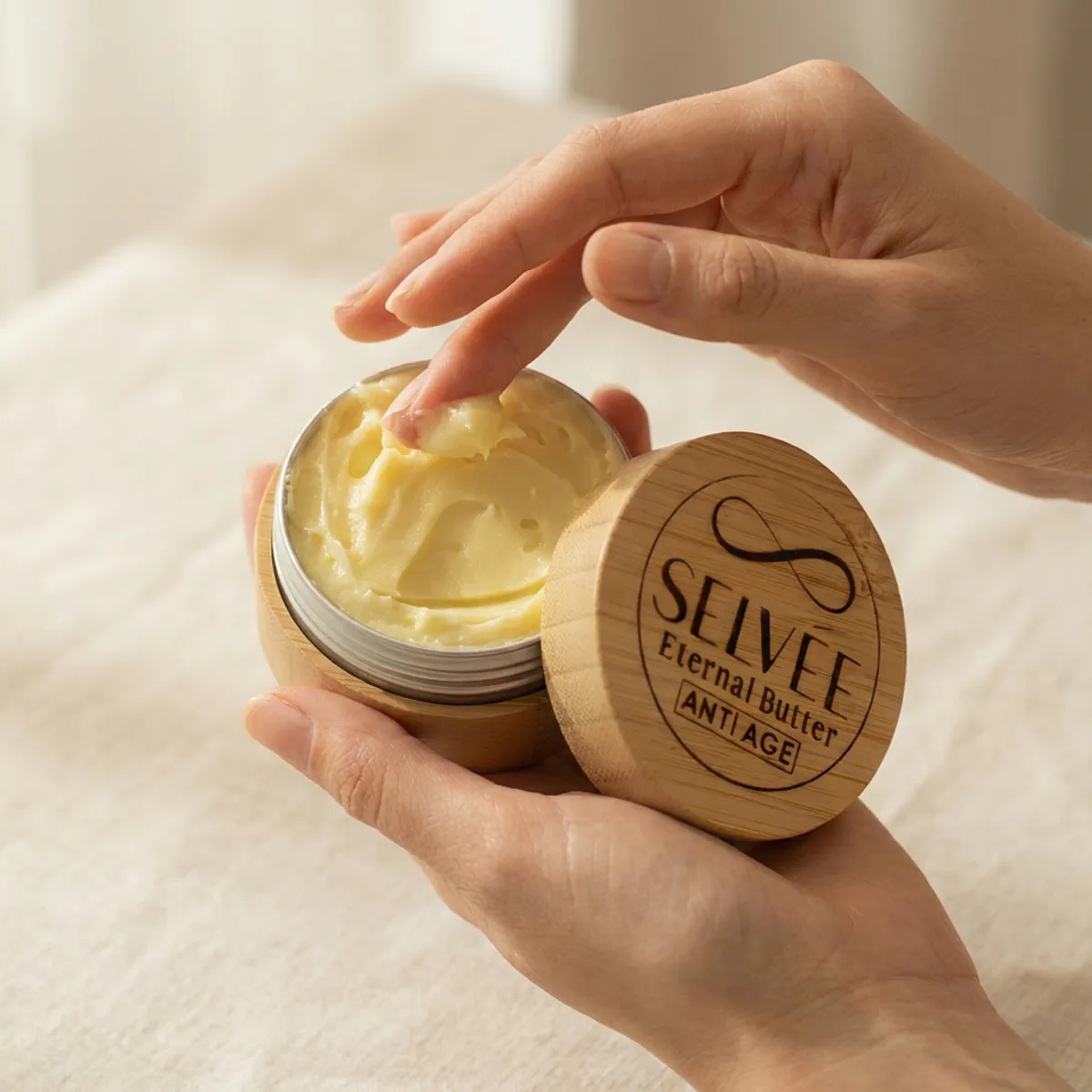 Ruke koje zahvataju Selvée Eternal Butter Anti Age kremu iz bambus teglice